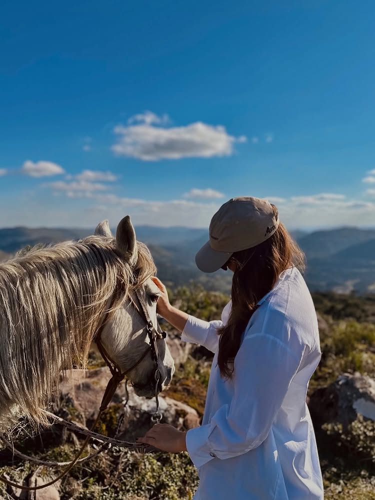 Mulher acariciando cavalo no mirante da Serra Catarinense